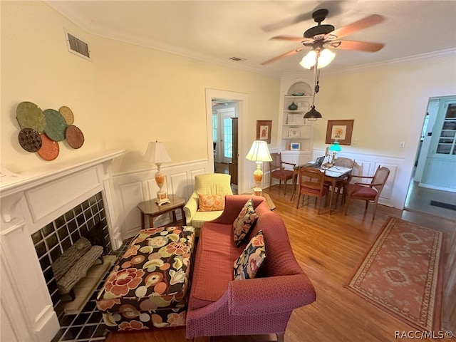 living room with crown molding, ceiling fan, and hardwood / wood-style flooring