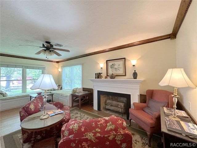 living room with ceiling fan, crown molding, and light hardwood / wood-style flooring