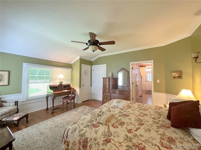 bedroom featuring hardwood / wood-style floors, ceiling fan, ornamental molding, a textured ceiling, and connected bathroom