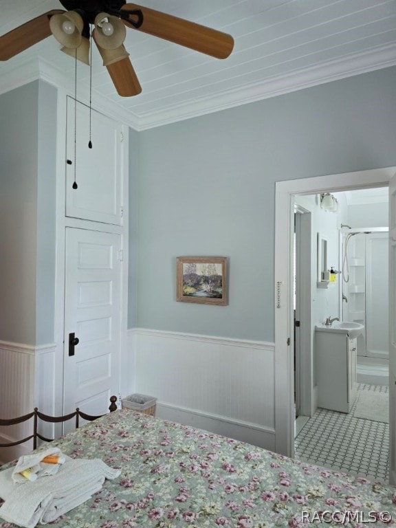 bedroom featuring ensuite bathroom, ceiling fan, and crown molding