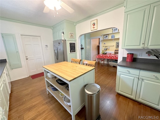 kitchen with stainless steel fridge, ceiling fan, dark hardwood / wood-style floors, and ornamental molding