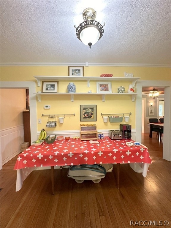 rec room with hardwood / wood-style floors, a textured ceiling, and ornamental molding