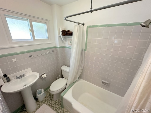 bathroom with tile patterned floors, shower / bath combination with curtain, toilet, and tile walls