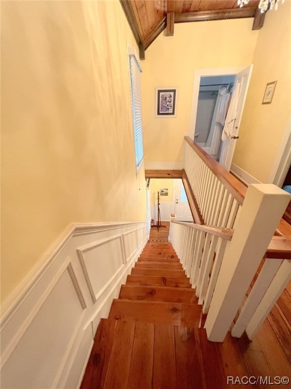 stairway with hardwood / wood-style floors and lofted ceiling