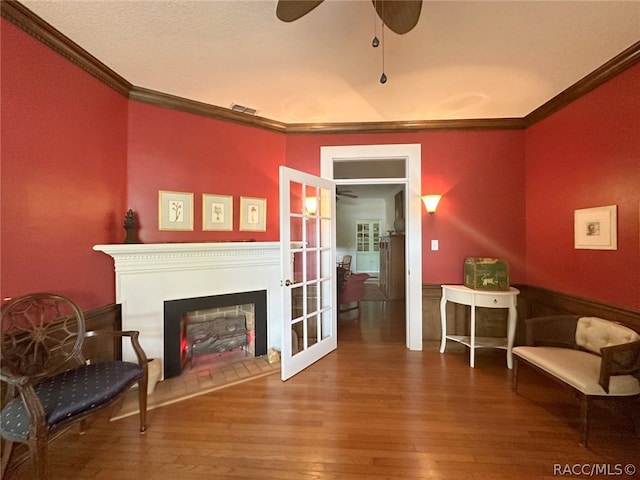 sitting room with wood-type flooring, crown molding, and french doors