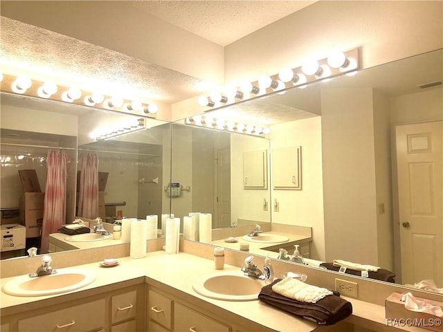 bathroom featuring vanity, a shower, and a textured ceiling