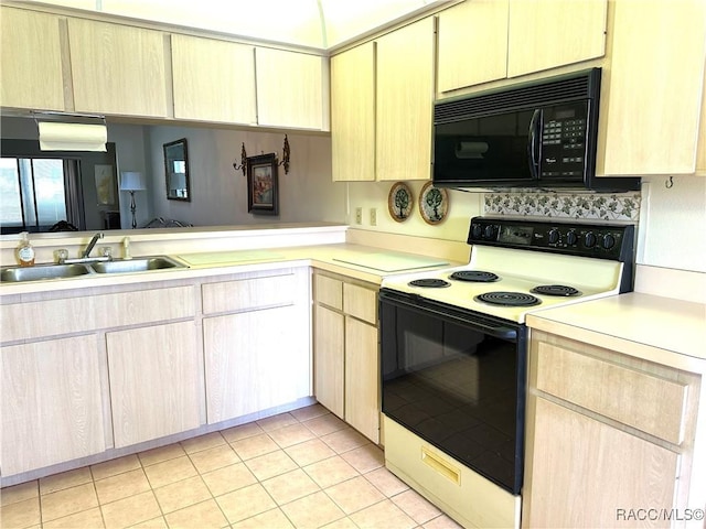 kitchen featuring light tile patterned flooring, light brown cabinetry, sink, and range with electric stovetop