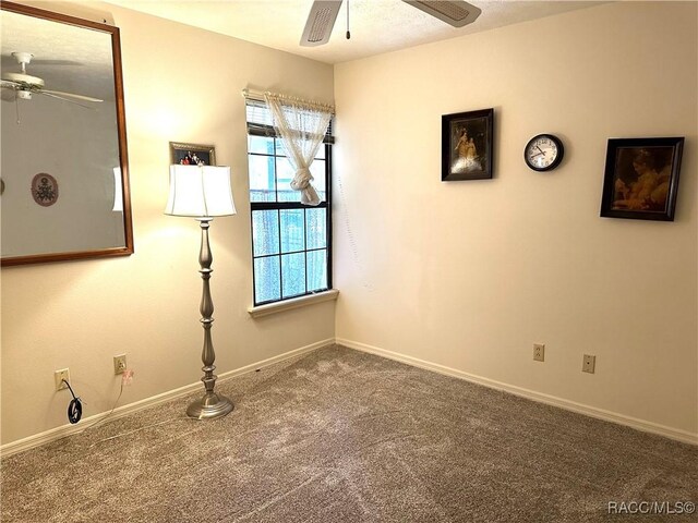 spare room with ceiling fan and carpet