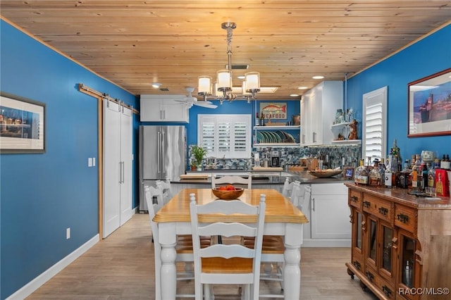 kitchen featuring a barn door, decorative light fixtures, white cabinetry, wooden ceiling, and stainless steel refrigerator