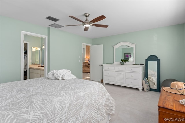 bedroom featuring light carpet, connected bathroom, and ceiling fan