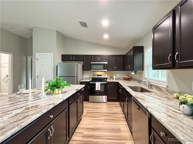 kitchen with lofted ceiling, light wood-style flooring, a sink, visible vents, and appliances with stainless steel finishes