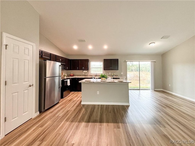 kitchen with light wood finished floors, visible vents, appliances with stainless steel finishes, light countertops, and dark brown cabinets