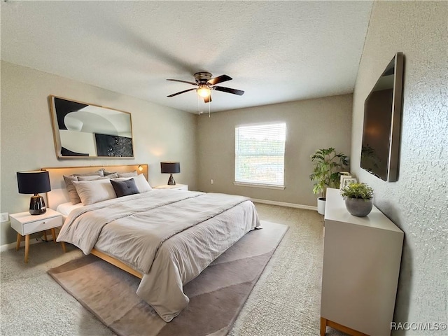 carpeted bedroom featuring a textured ceiling, a ceiling fan, and baseboards