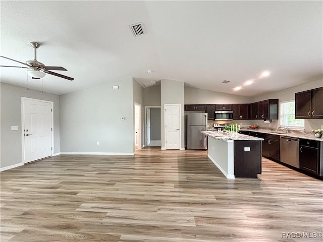 kitchen with visible vents, a center island, stainless steel appliances, dark brown cabinets, and light wood-style floors