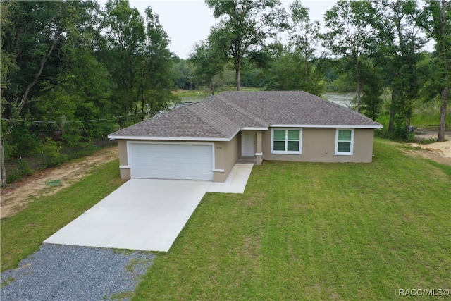 ranch-style house featuring an attached garage, driveway, a front yard, and stucco siding