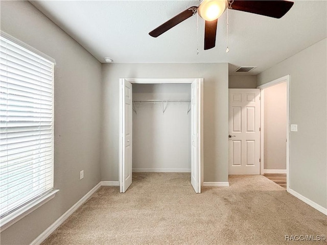 unfurnished bedroom with light carpet, baseboards, visible vents, a ceiling fan, and a closet