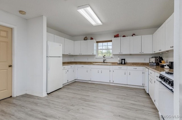 kitchen with a sink, white cabinetry, and white appliances