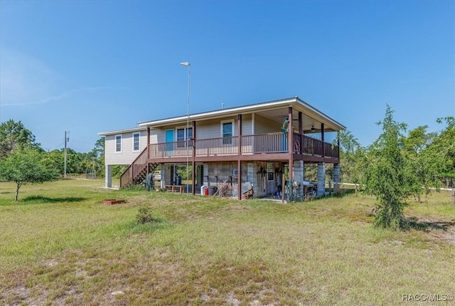 rear view of property with a wooden deck, a yard, and stairway