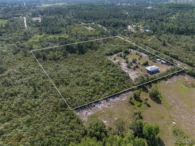 drone / aerial view with a wooded view