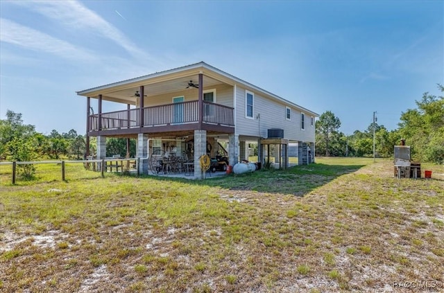 back of house with a ceiling fan, a lawn, a deck, fence, and a patio