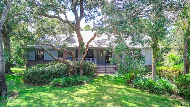 exterior space with covered porch and a front lawn