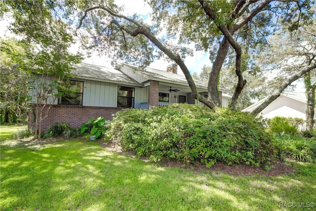 view of front of house with ceiling fan and a front lawn