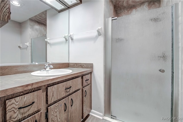 bathroom featuring wood-type flooring, vanity, and a shower with door