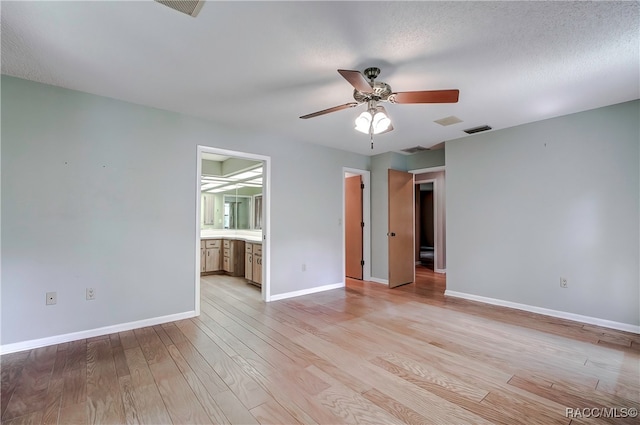 unfurnished room featuring a textured ceiling, light hardwood / wood-style flooring, and ceiling fan