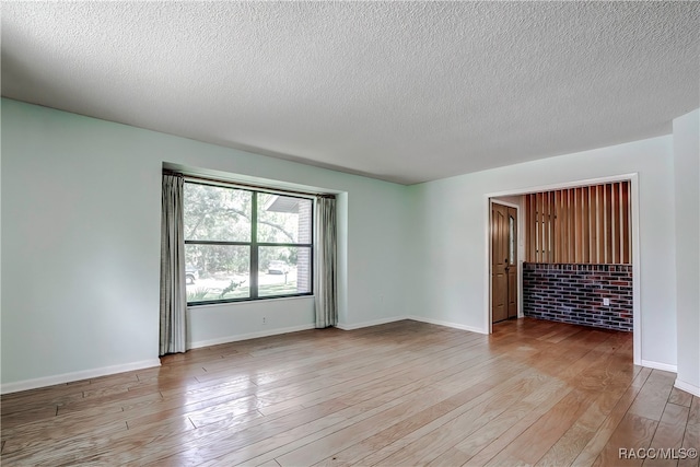 empty room featuring light hardwood / wood-style floors and a textured ceiling