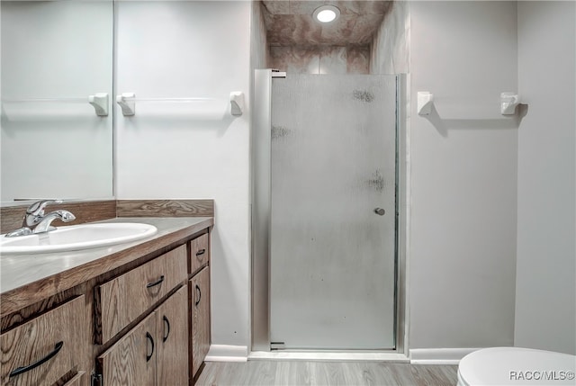 bathroom featuring a shower with door, vanity, and hardwood / wood-style flooring