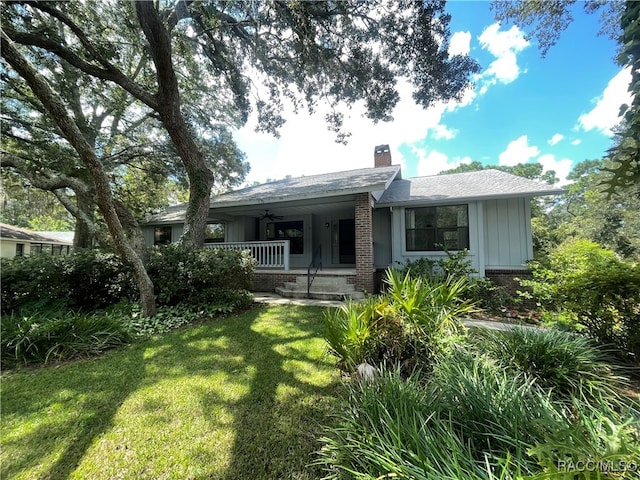 rear view of property with a lawn, ceiling fan, and a porch