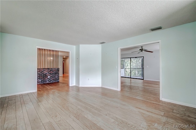 empty room featuring a textured ceiling, light hardwood / wood-style floors, and ceiling fan