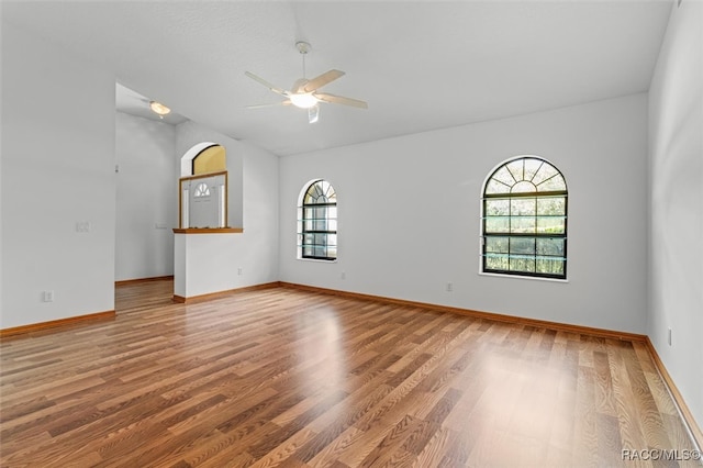 spare room featuring hardwood / wood-style flooring, ceiling fan, and a healthy amount of sunlight