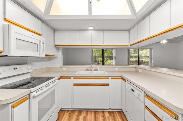 kitchen featuring white cabinets, white appliances, kitchen peninsula, and sink