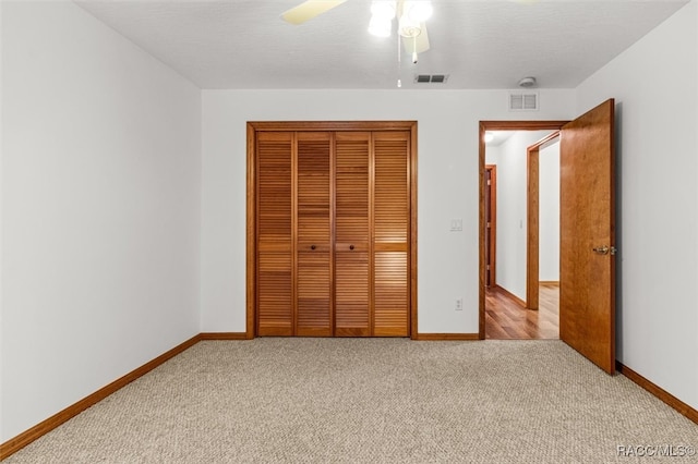 unfurnished bedroom with ceiling fan, a closet, and light colored carpet