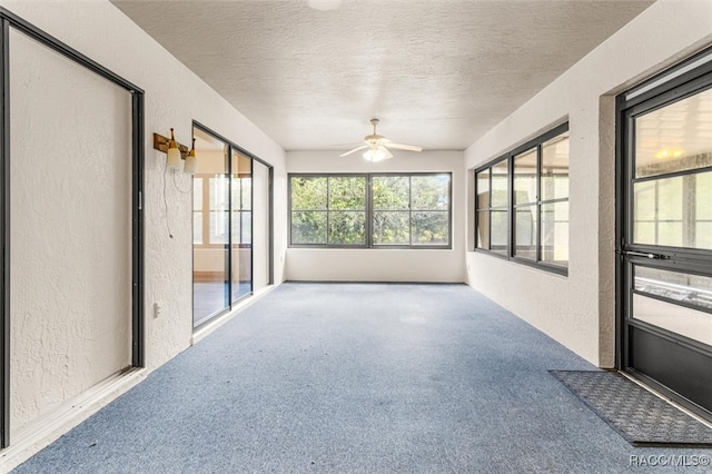 unfurnished sunroom with ceiling fan