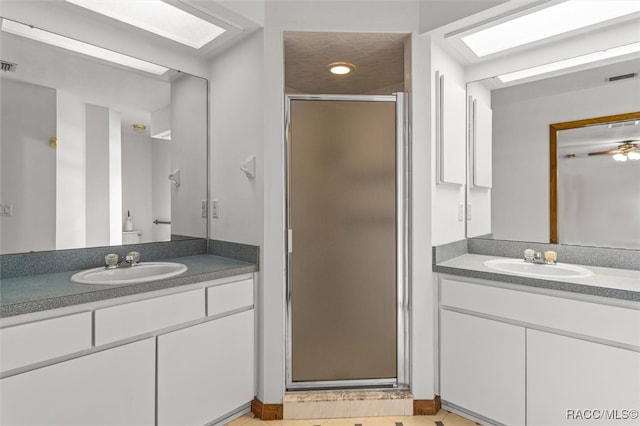 bathroom featuring vanity, a skylight, and a shower with shower door