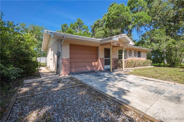 728 S Juniper Way, Inverness, FL 34450 - view of front of home featuring an attached garage, concrete driveway, and stucco siding