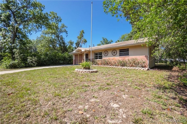 728 S Juniper Way, Inverness, FL 34450 - single story home with a garage, a front yard, driveway, stucco siding, and brick siding