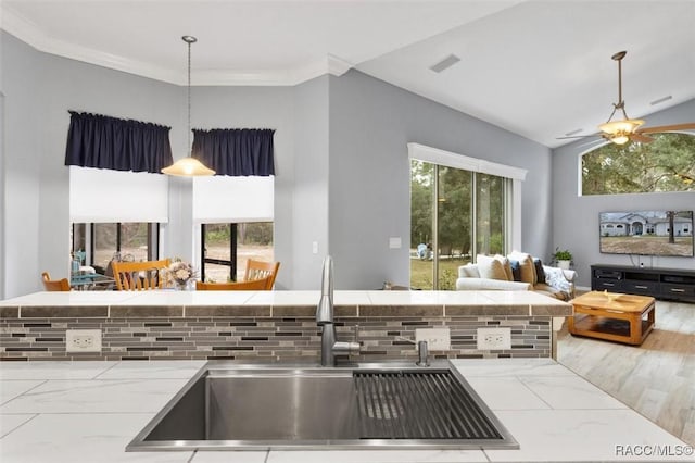 kitchen featuring decorative light fixtures, light countertops, a sink, and visible vents