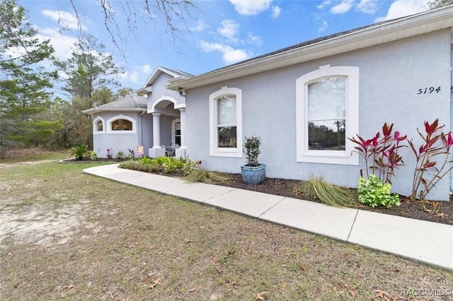 view of front of house featuring a front lawn and stucco siding