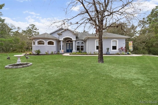 ranch-style house featuring stucco siding and a front yard