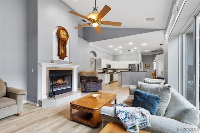 living room featuring a warm lit fireplace, ceiling fan, light wood-style flooring, visible vents, and ornamental molding