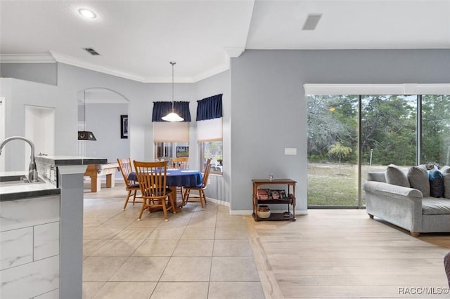 dining area with baseboards, visible vents, and crown molding