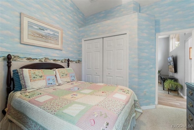 bedroom featuring baseboards, a closet, light carpet, and wallpapered walls