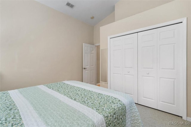 bedroom with visible vents, vaulted ceiling, and a closet