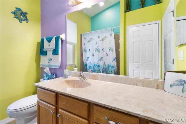 full bathroom with a closet, a shower with shower curtain, vanity, and toilet