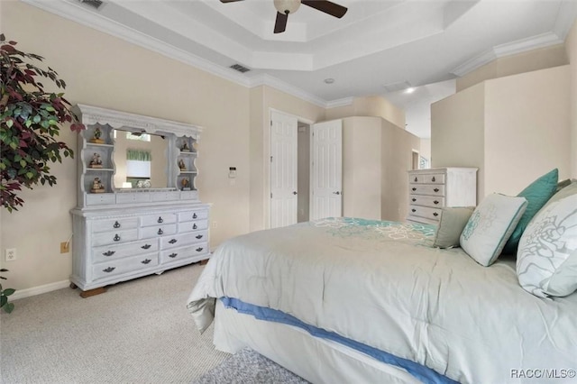 bedroom with light carpet, baseboards, visible vents, a raised ceiling, and crown molding