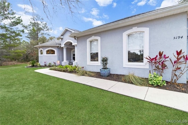 view of front of house with a front yard and stucco siding