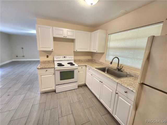 kitchen with white appliances, white cabinetry, light hardwood / wood-style flooring, and sink